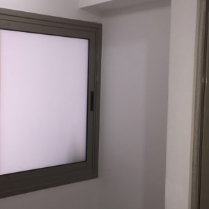 קיר צבוע בלבן עם חלון ומנורה