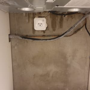 שקע חשמל על קיר בטון עם חוטים חשמליים