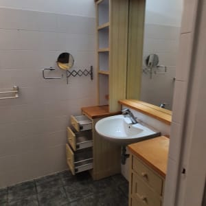 כיור עם ברז, ארונות פתוחים, מראה קטנה על הקיר