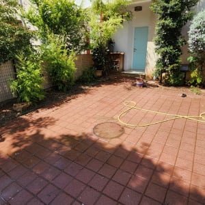 צינור מים צהוב על רצפת מרפסת מרוצפת