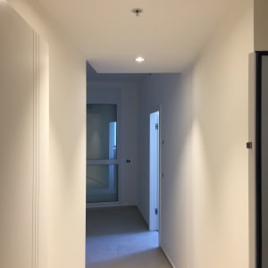 מסדרון עם קירות גבס ותאורה שקועה בתקרה