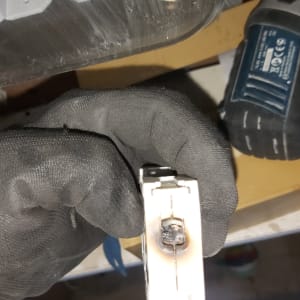 כפפת עבודה מחזיקה רכיב חשמלי שרוף