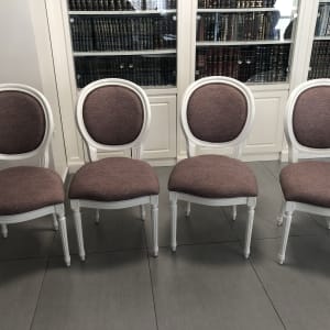 ארבעה כיסאות מרופדים בבד סגול על רקע ספרייה