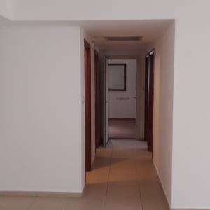 מסדרון עם קירות צבועים בלבן ודלתות עץ