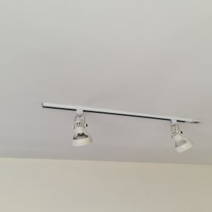 שני פנסי מסילה מותקנים על תקרה לבנה