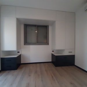 ארונות קיר לבנים עם מגירות שחורות בחדר