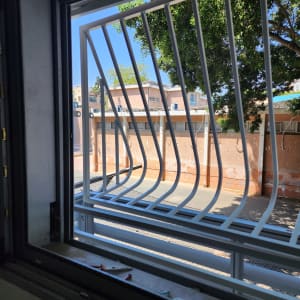 סורגי מתכת לבנים בחלון פתוח