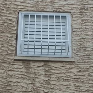 חלון עם סורגים על קיר טיח