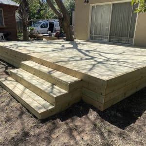 דק עץ עם מדרגות בחצר בית