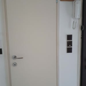 דלת לבנה עם ידית מתכת ומנעול