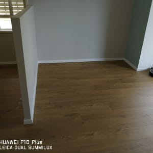 רצפת פרקט עץ חום עם רובוט שואב