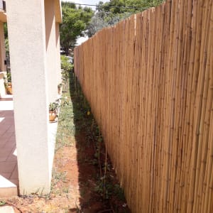 צינור השקיה בגינה ליד גדר במבוק