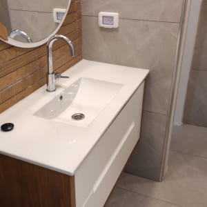 כיור לבן עם ברז מתכת בחדר אמבטיה