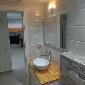 כיור עגול על משטח עץ בחדר אמבטיה מואר