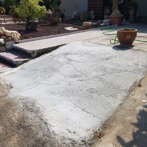 משטח בטון חדש עם צינור ירוק בגינה