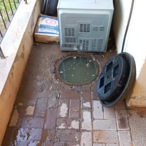 פתח ביוב פתוח עם מכסה מונח בצד