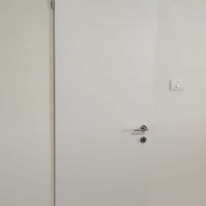 דלת לבנה עם ידית כסופה ומנעול