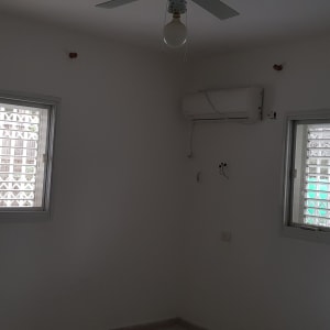 חדר עם קירות לבנים, חלונות ומזגן