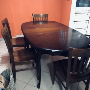 שולחן עץ עם כיסאות בחדר עם קיר כתום