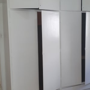 ארונות לבנים עם דלתות פתוחות בתהליך שיפוץ