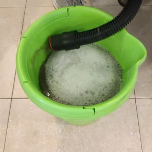 דלי ירוק עם קצף ומכשיר שאיבה