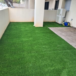 דשא סינתטי על מרפסת עם צינור מים מגולגל