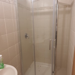 מקלחון זכוכית עם דלתות הזזה וברז מקלחת