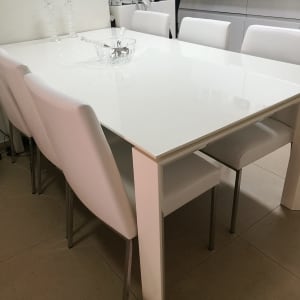 שולחן לבן עם כיסאות מרופדים בלבן