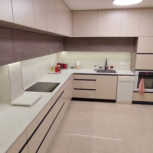מטבח מודרני עם ארונות בהירים, תנור ומקרר נירוסטה