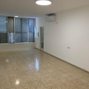 חדר ריק עם רצפה נקייה וחלונות גדולים