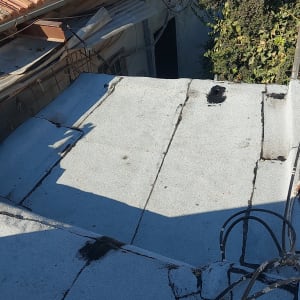 גג עם יריעות איטום וסדקים מתוקנים בזפת