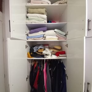 ארון בגדים עם מגבות מקופלות ובגדים תלויים