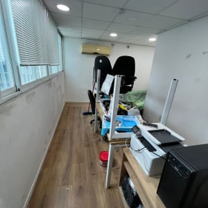 פח צבע אדום על הרצפה ליד שולחן