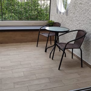 ריצוף עץ חדש במרפסת עם שולחן וכיסאות