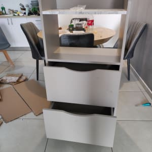 ארון עם מגירות פתוחות וחלקי קרטון על הרצפה