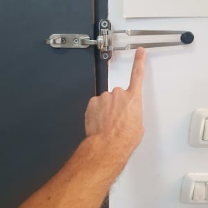 יד מצביעה על מנעול דלת מתכת