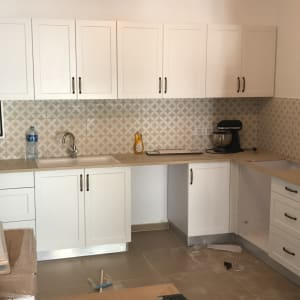 מטבח עם ארונות לבנים, מקרר ומיקסר שחור