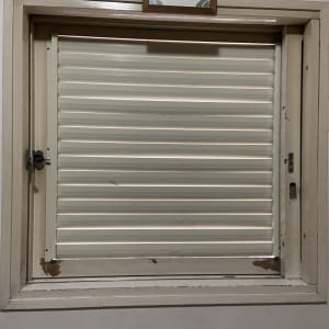 תריס אלומיניום סגור במסגרת חלון עץ ישנה