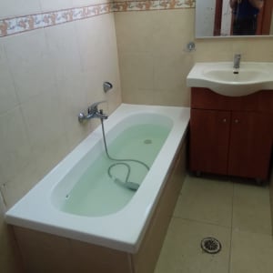 אמבטיה עם מים, ברז ומקלחת יד