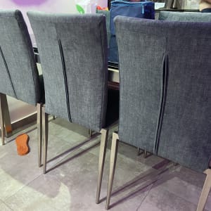 כיסאות מרופדים אפורים ליד שולחן עם רגלי מתכת