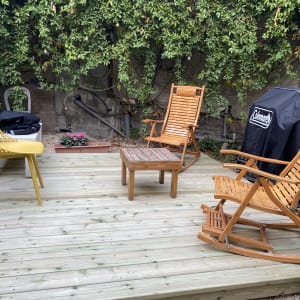 רצפת עץ עם כיסאות ושולחן בגינה