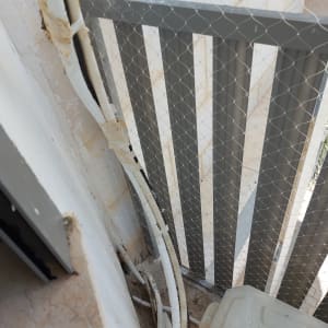 רשת מתכת מותקנת על מעקה למניעת כניסת יונים
