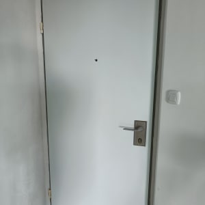 דלת לבנה עם ידית מתכת ומנעול