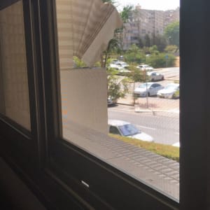 חלון אלומיניום עם מסגרת כהה ותריסים