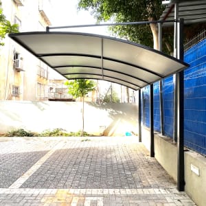 סככה מתכתית עם גג קמור מעל שביל מרוצף