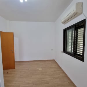 חדר ריק עם קירות לבנים ורצפת עץ