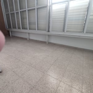 חדר ריק עם חלונות גדולים ורצפת אריחים