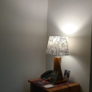 מנורה עם אהיל מעוטר על שולחן עץ