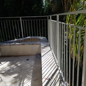 מעקה מתכת לבן על מרפסת עם צללים