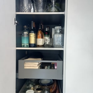 ארון עם בקבוקי יין, כוסות וכלי מטבח מאורגנים